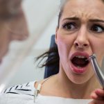 Young woman scared during a dental check-up at clinic